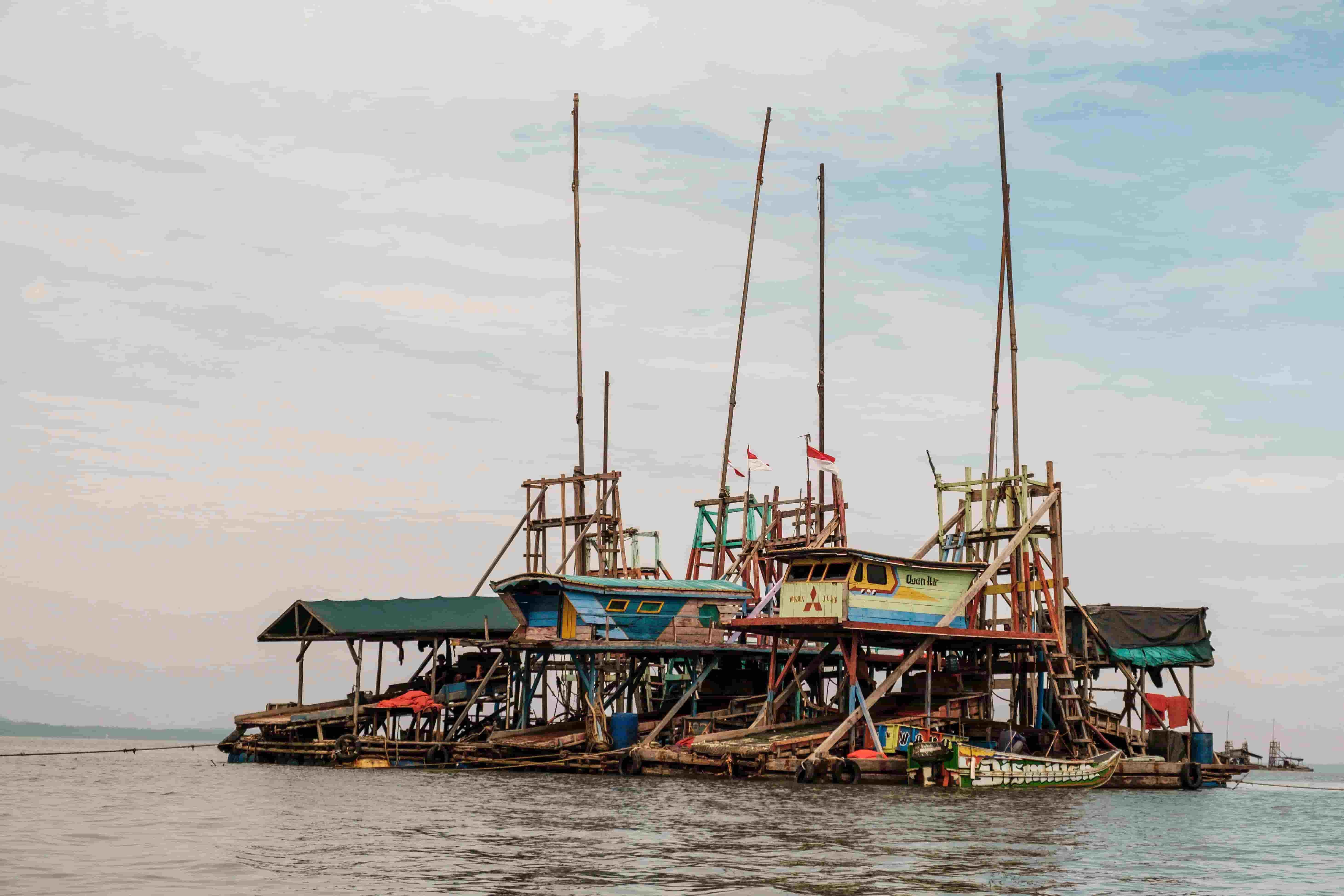 A trio of wooden pontoons floats on peaceful water