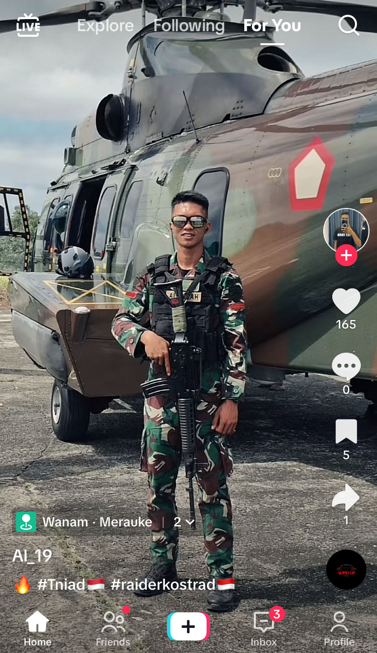 A screen shot from TikTok with an armed soldier posing in front of a helicopter